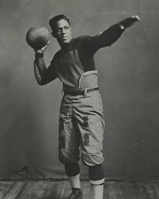 Fritz Pollard in football uniform, throwing pose, 1916